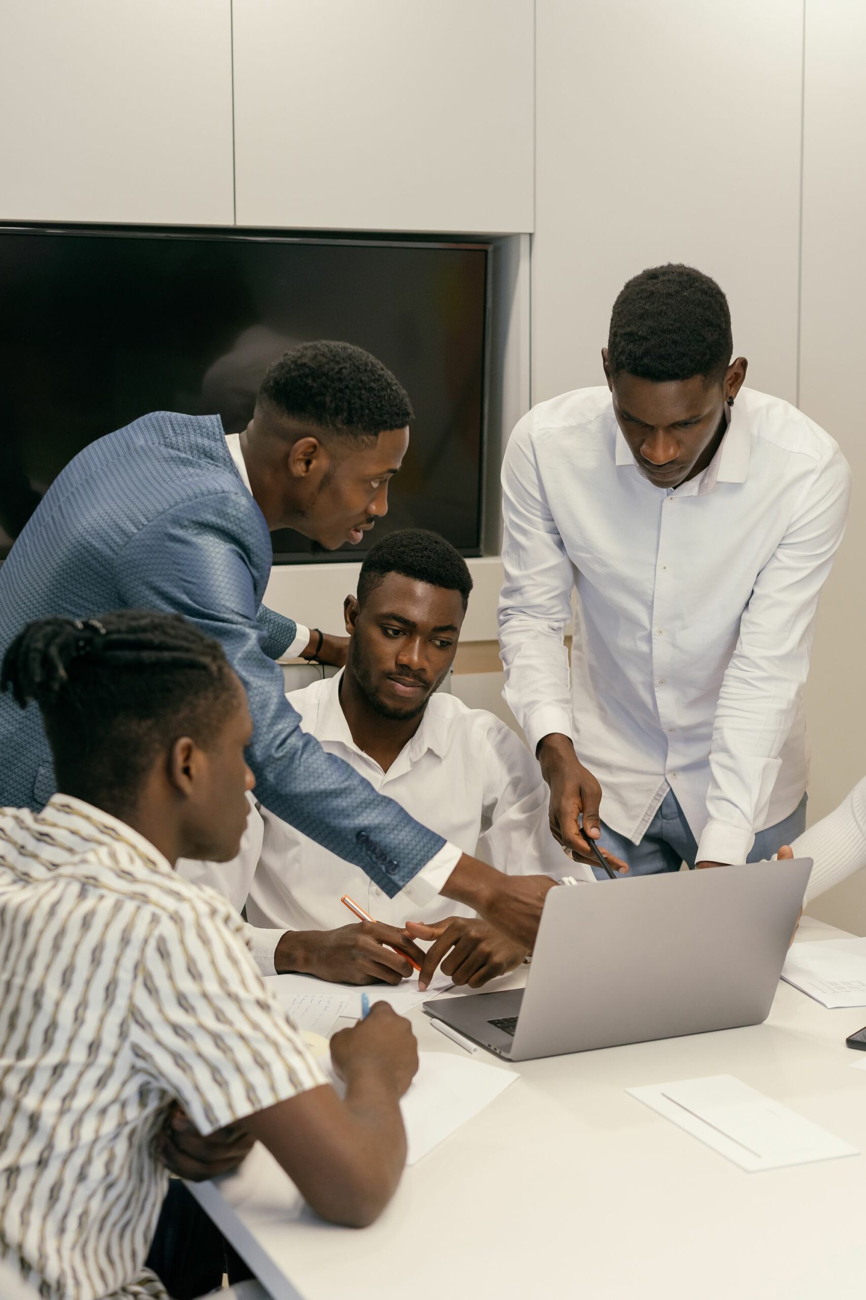 Team of professionals working together around a laptop